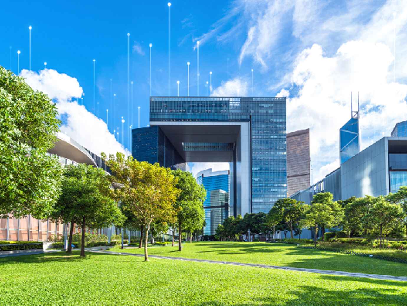 Corporate buildings behind a lawn and tress, with OpenBlue graphics in the background