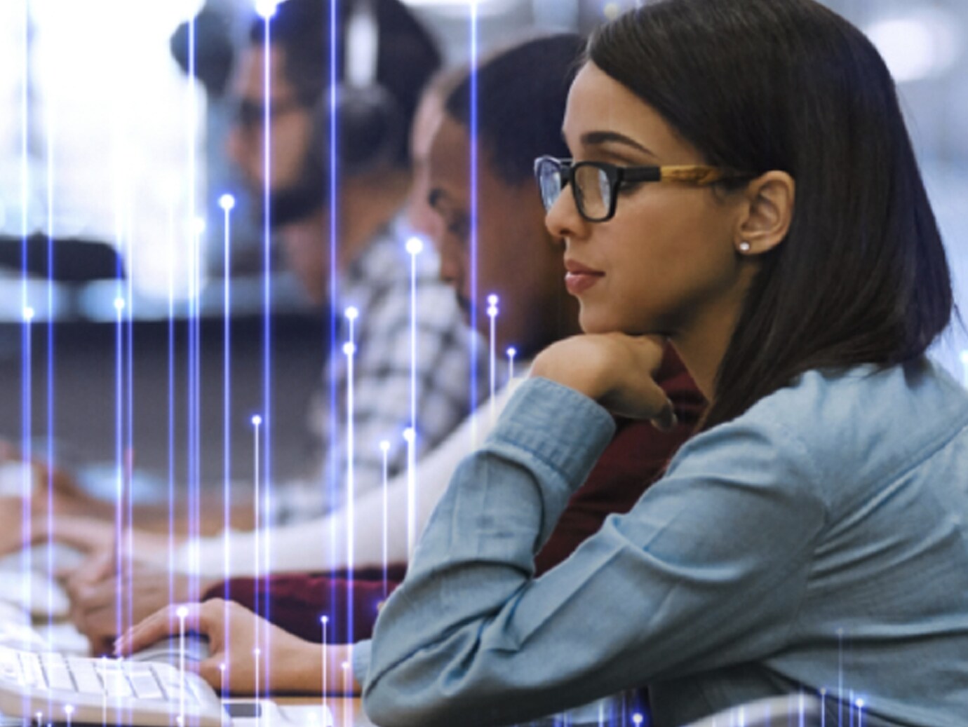 A young woman wearing glasses and working on a laptop beside a row of people, overlaid with OpenBlue graphics