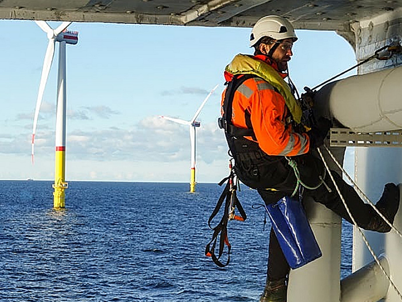 Technician in safety gear inspecting an offshore platform