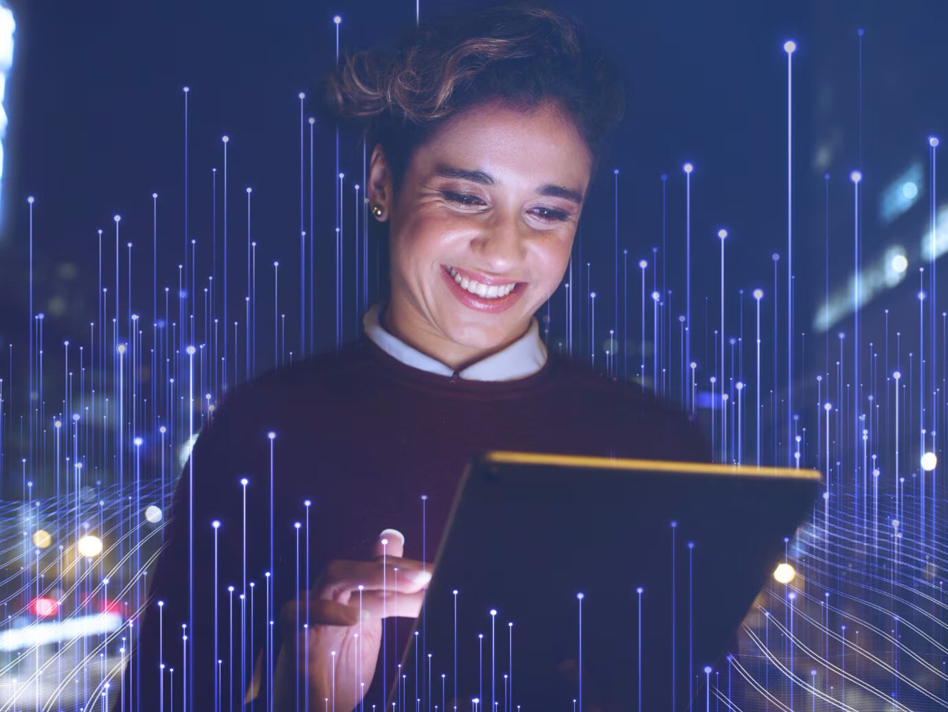 A woman smiling down at a tablet overlaid with graphics depicting transmission nodes